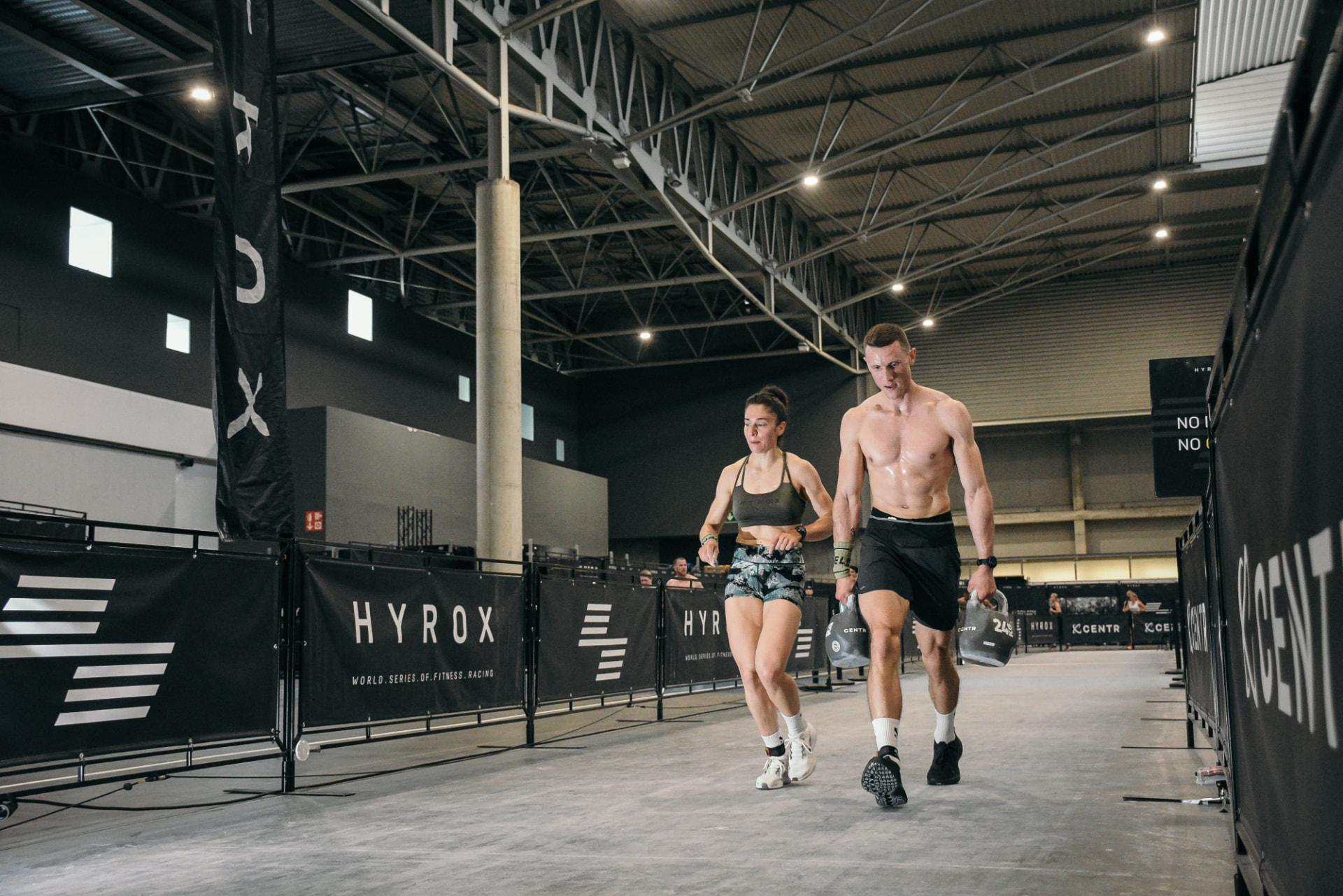 Athlètes portant des kettlebells lors d'une course Hyrox — programme Hyrox